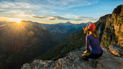 Naklejka na ściany i meble A hiker watches sunset over the Bitteroots from Bear Creek Overlook in the Selway-Bitterroot Wilderness.