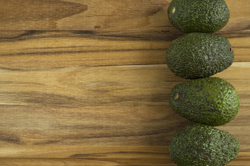 Avocados lined up on right side of cutting board
