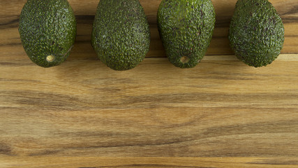 Avocados lined up on top side of photo