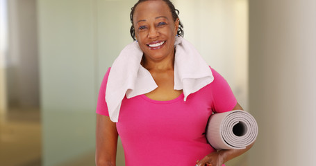 An elderly African American woman poses for a portrait after her workout