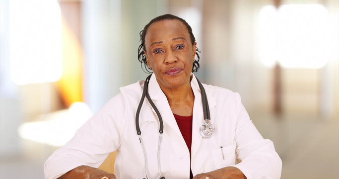 An Older Black Doctor Looking At Camera With Concern