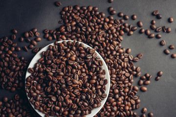 coffee beans on a light plate and on a table