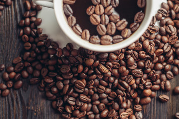 cup with a drink and coffee beans on a table