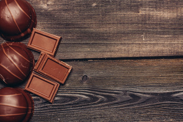 broken chocolate segments on a wooden background and a cake
