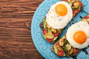 Sandwich with egg, tomato, greens, and mushrooms