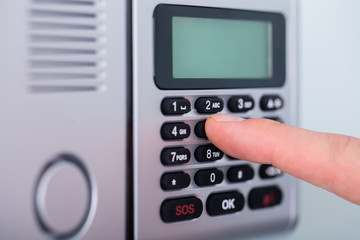 Person's Finger Setting Security Alarm