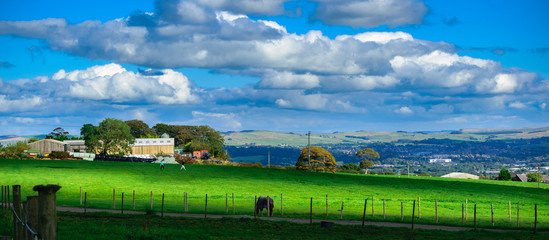 Farm on summer in Lancashire, blurred two people walking on the grass, 16:7 aspect ratio, Forest Of...