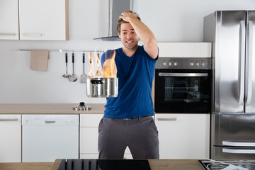 Surprised Man Holding Utensil On Fire