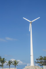 Fototapeta na wymiar Wind turbine or windmill generating electricity on blue sky back