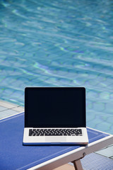 Laptop computer near swimming pool