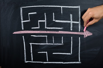 Person Drawing Straight Red Line Over Maze