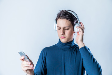 young man wearing wireless headphone and listening to music with smart phone