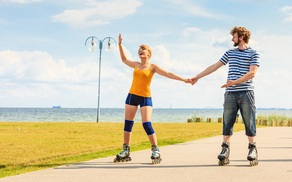 Young couple on roller skates riding outdoors