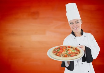 Female chef holding a tray of pizza