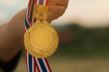 hand raised and holding gold medal against white background, awa - obrazy, fototapety, plakaty
