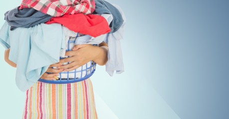 Mid section of woman holding basket full of clothes