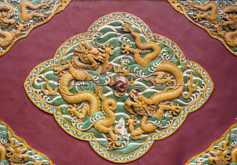 Two dragons are curvetting with a pearl, wall in Beihai park,