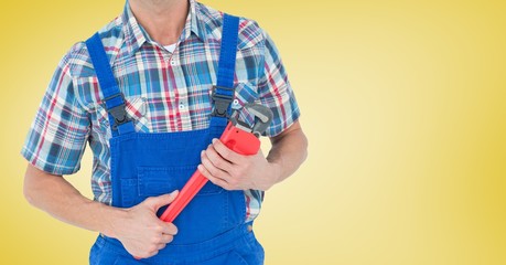 Mid section of handyman holding pipe wrench