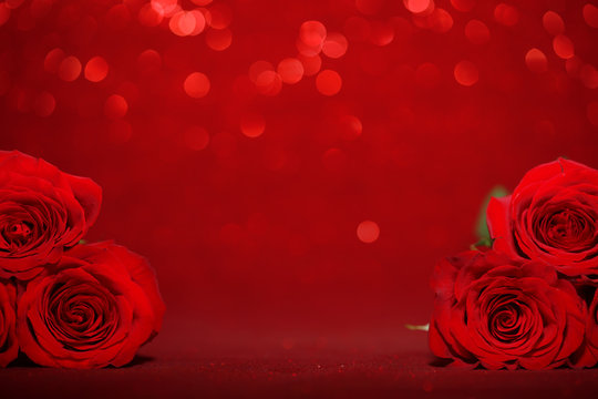 Beautiful red roses on sparkling red background