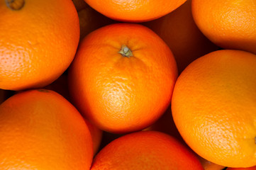 Fresh whole oranges in a box on a wooden background