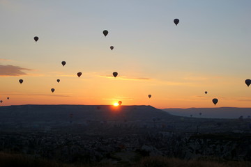 Travel to Goreme, Cappadocia, Turkey. The sunrise in the mountains with a lot of air hot balloons in the sky.