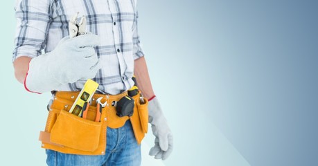 Fototapeta na wymiar Mid section of handyman with tool belt and wrench