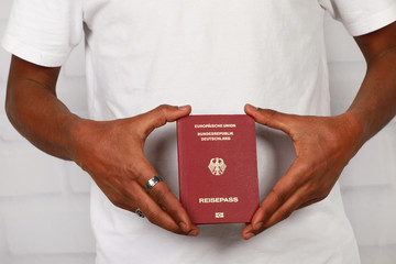 schwarze Hände halten auf deutschen Pass