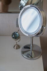silver dressing mirror on white table top