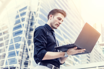 Caucasian businessman use of the notebook computer at outdoor