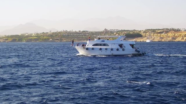 Pleasure Boat Floats on the Waves of the Red Sea on the Background of Coast and Beaches in Egypt
