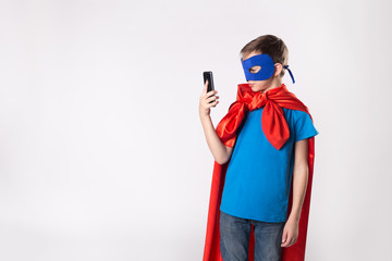 Superhero child using mobile phone