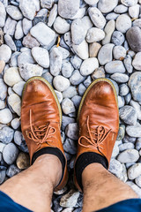 men leather shoe on round pebble stone background