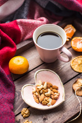 wooden tray with cup of coffee, nuts and orange