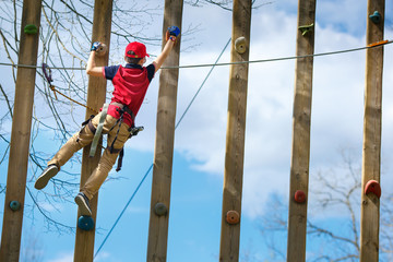 Cute little boy enjoying his time in climbing adventure park