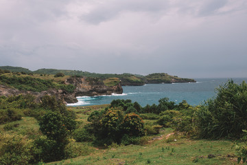 Fototapeta premium Green field in the shore of island, azure water, Bali, Indonesia