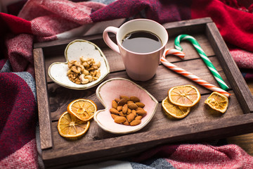 Fototapeta na wymiar wooden tray with cup of coffee, nuts and orange