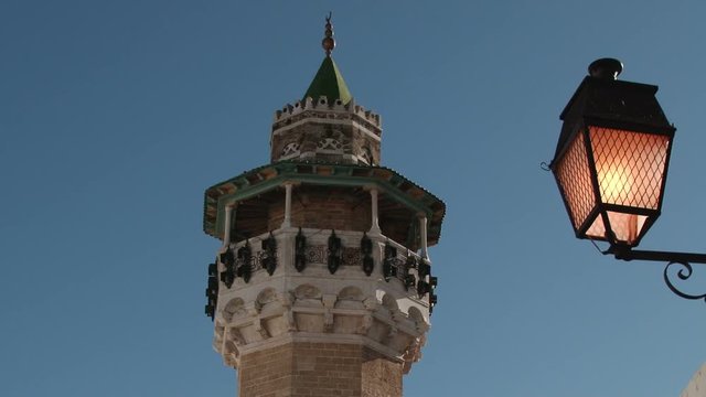Minaret of the Youssef Dey Mosque and lit streetlamp in Tunis, Tunisia
