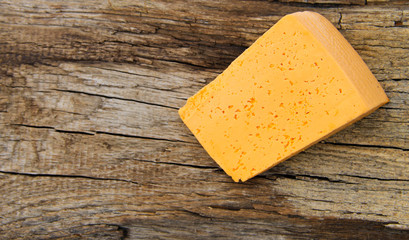 Piece of cheese on a wooden background