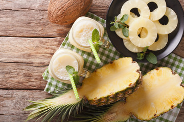 Cocktail of pineapple and coconut in glass jar closeup. Horizontal top view