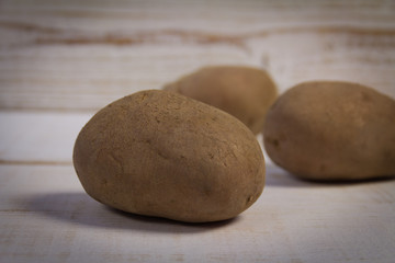 Fototapeta na wymiar Potatoes on wooden background