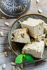 Halva of sunflower seeds on a bronze plate.