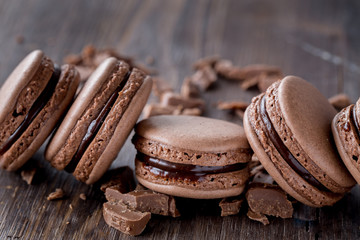 Chocolate macarons on a rustic wooden table. 