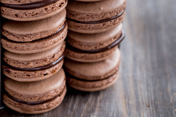 Fototapeta na wymiar Chocolate macarons on a rustic wooden table