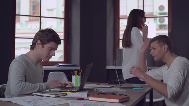 Smiling co workers have fun in the office. Young businessman and businesswoman at work.