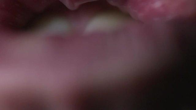 Closeup shot of an adults mouth with saliva shouting and seeming aggressive  