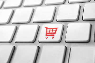 close-up of a keyboard with a shopping cart icon. E-commerce concept