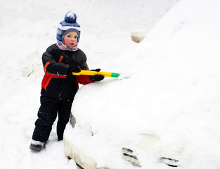 Fototapeta na wymiar The little boy cleans a car from the snow