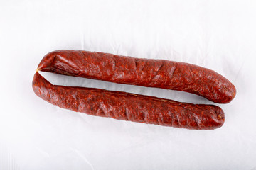 Smoked salami sausage on white.