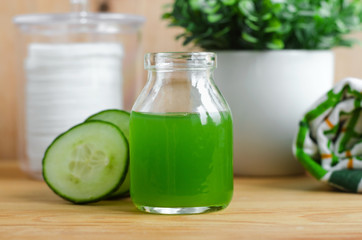 Cucumber juice in a small glass jar for preparing natural facial toner. Homemade cosmetics.
