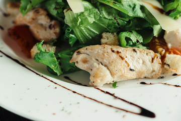 Caesar salad with chicken on white dish